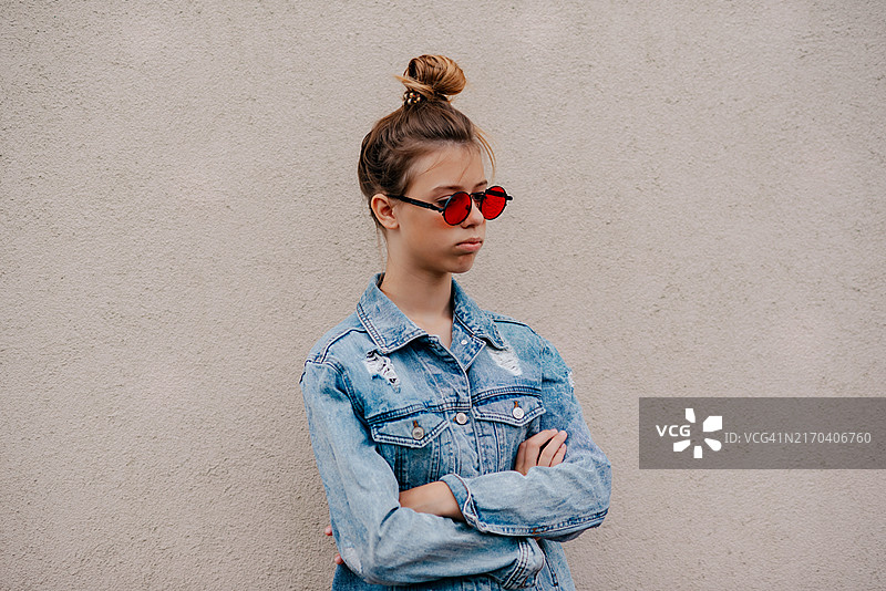 女学生被同学欺负，独自站在墙边，教育概念图片素材