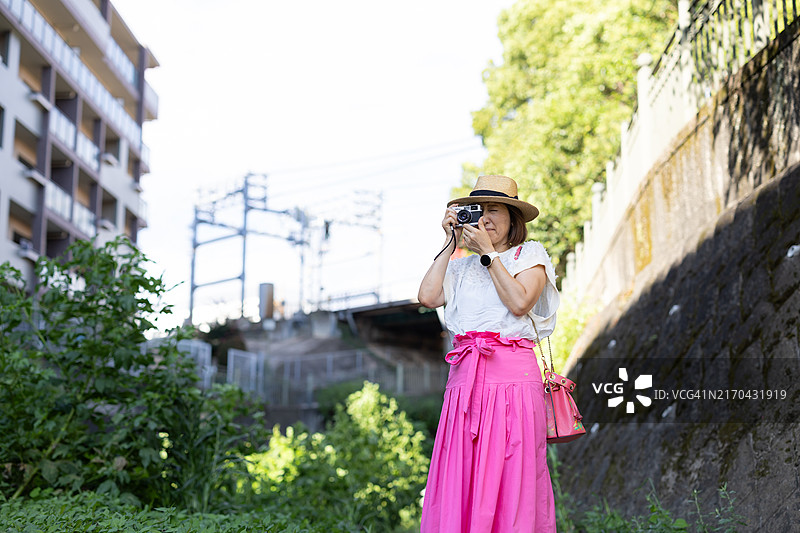 度假时用胶片相机拍照的女人图片素材