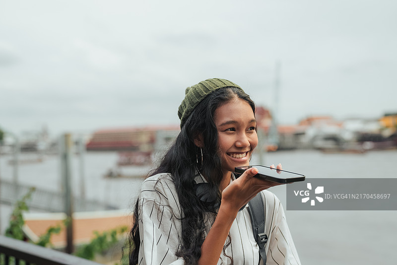 在曼谷使用AI翻译应用程序了解交通方式的年轻亚洲人图片素材