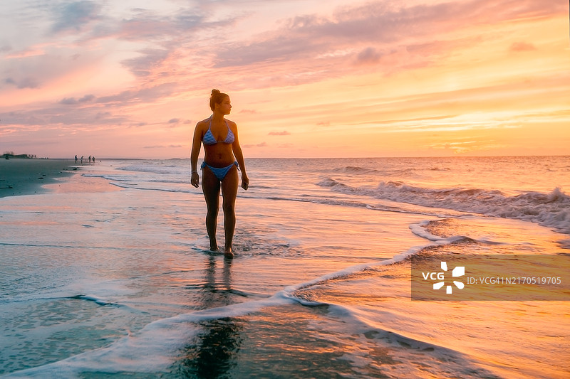 少女在日出时享受海滩图片素材