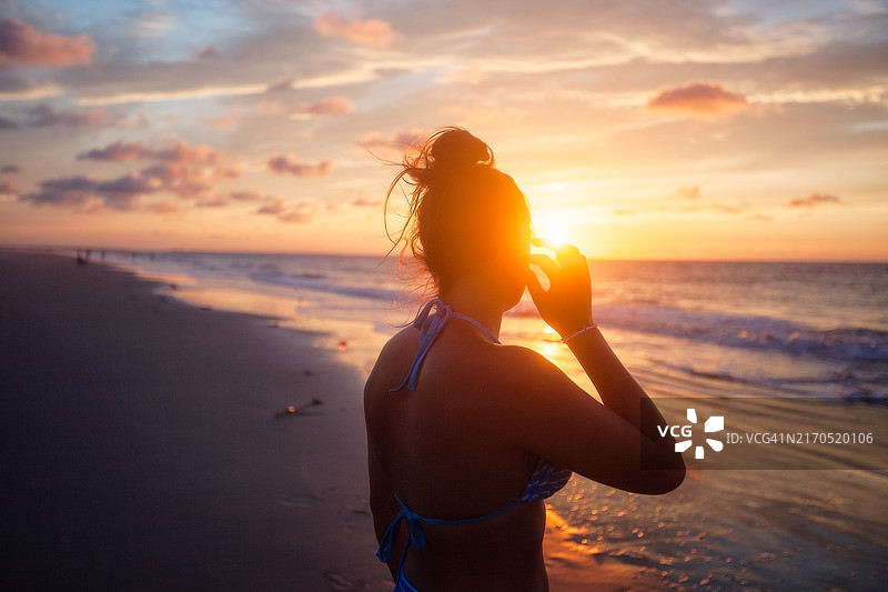 少女在日出时享受海滩图片素材