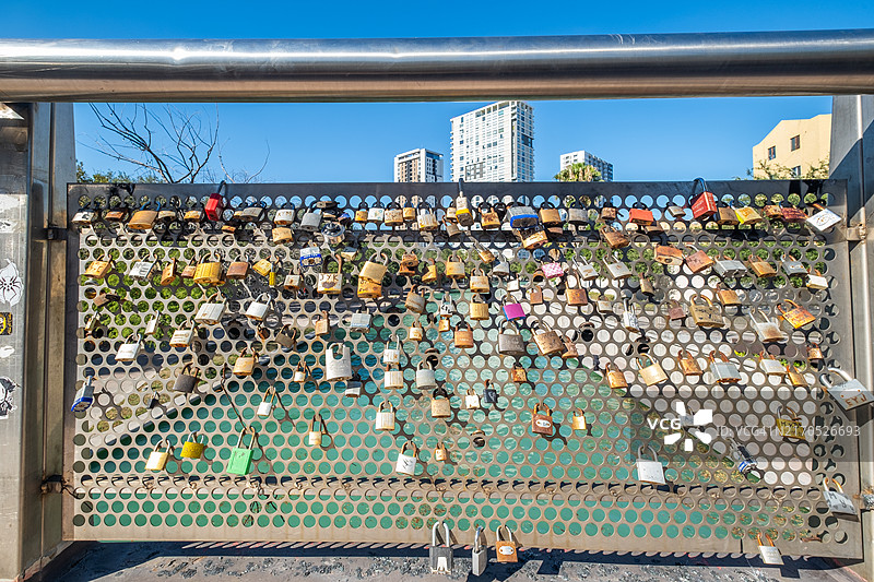 在墨西哥蒙特雷美丽的圣露西亚河步道上，阳光明媚的日子里，桥上的锁。图片素材