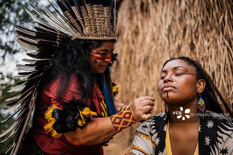 土著妇女在探险期间为游客进行传统绘画图片素材