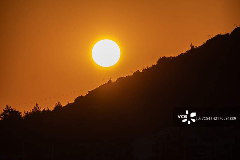 橙色天空映衬下群山剪影的美景图片素材