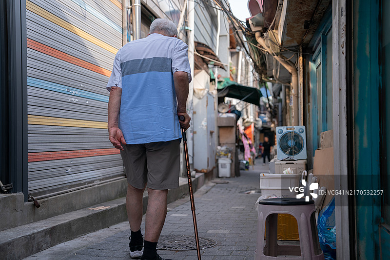 老年人和中年人在小巷里行走图片素材