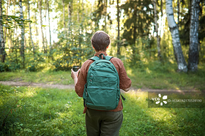享受自然：少女在森林中休息，用可重复使用的杯子喝茶图片素材