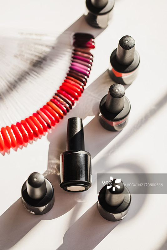 美甲沙龙白色桌子上的黑色指甲油瓶图片素材