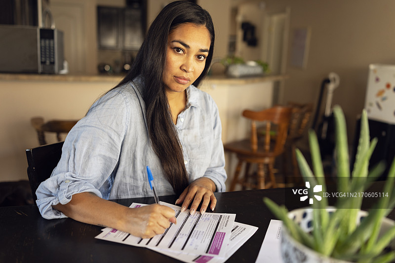 填写缺席投票选票的年轻西班牙裔女子图片素材