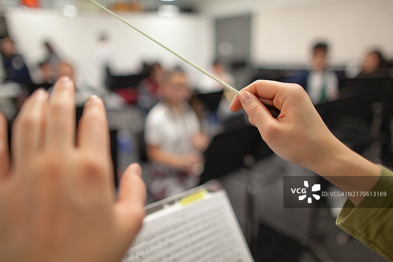 乐队指挥在学校教室里指导初中生合奏图片素材