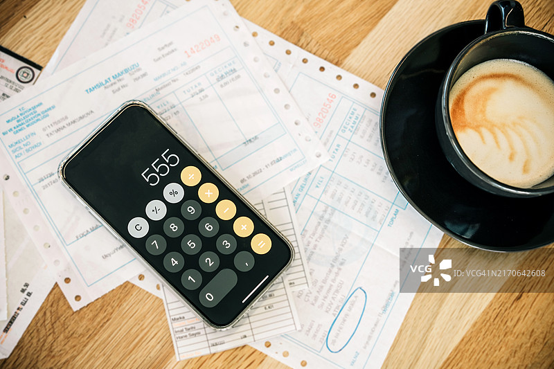 桌子上的电话和水电费账单上的计算器，俯视图图片素材