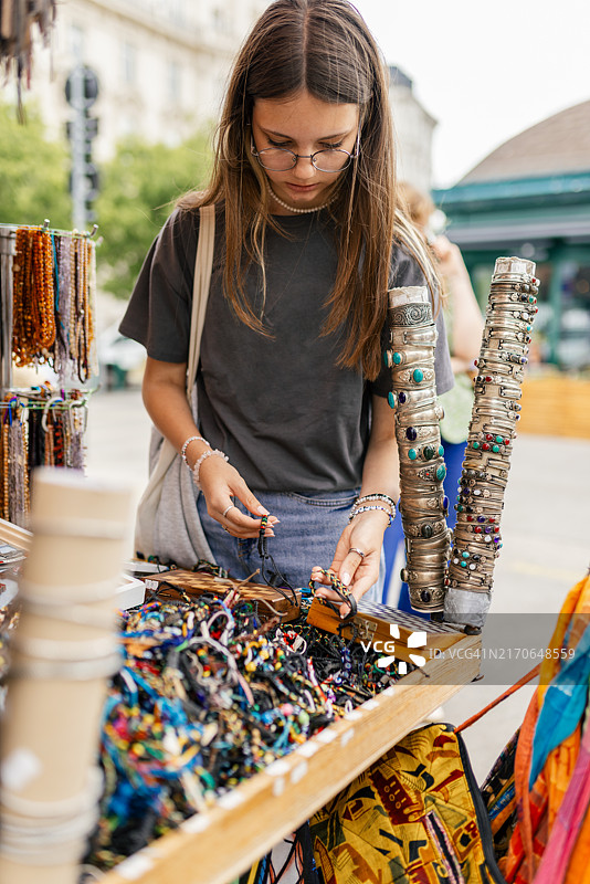 在街边摊看首饰的少女图片素材