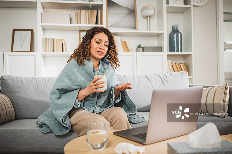 年轻女人在家中进行在线医生预约图片素材