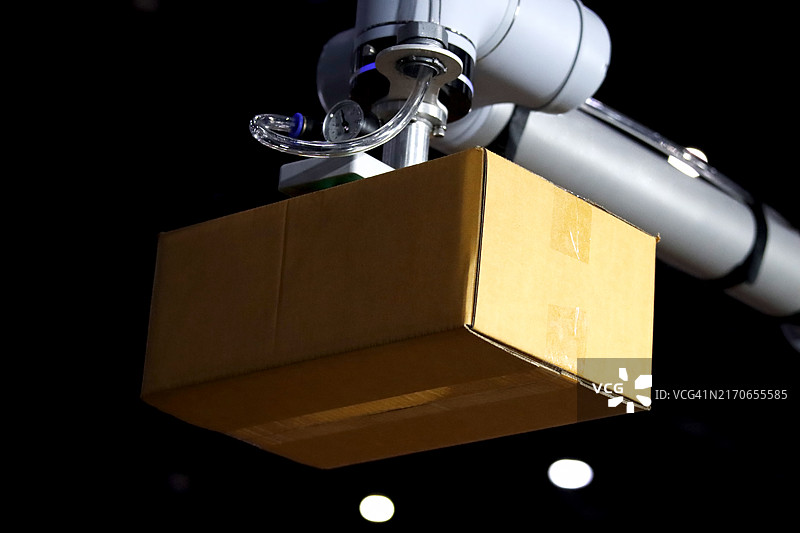 机器人手臂在现代化仓库生产线上搬运纸箱图片素材