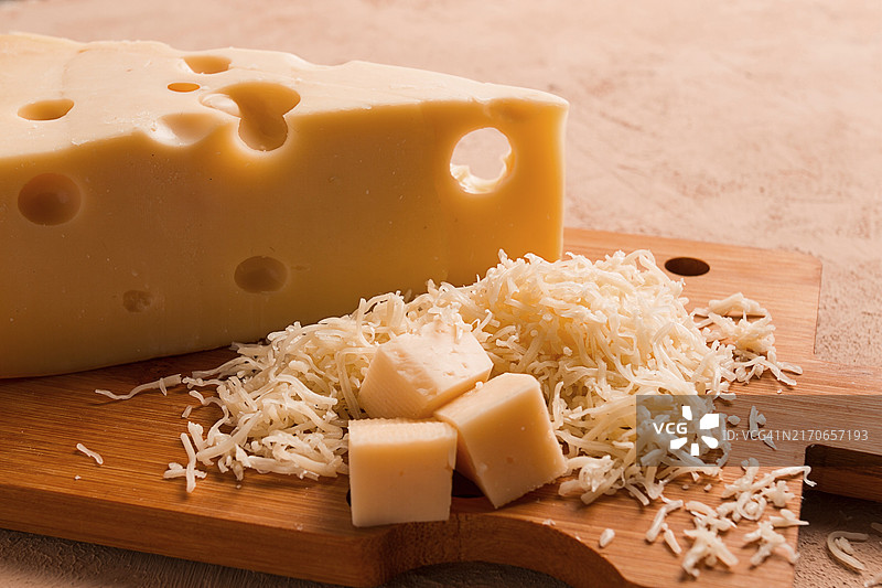 砧板上的马斯丹碎奶酪、磨碎器和奶酪刀，特写图片素材