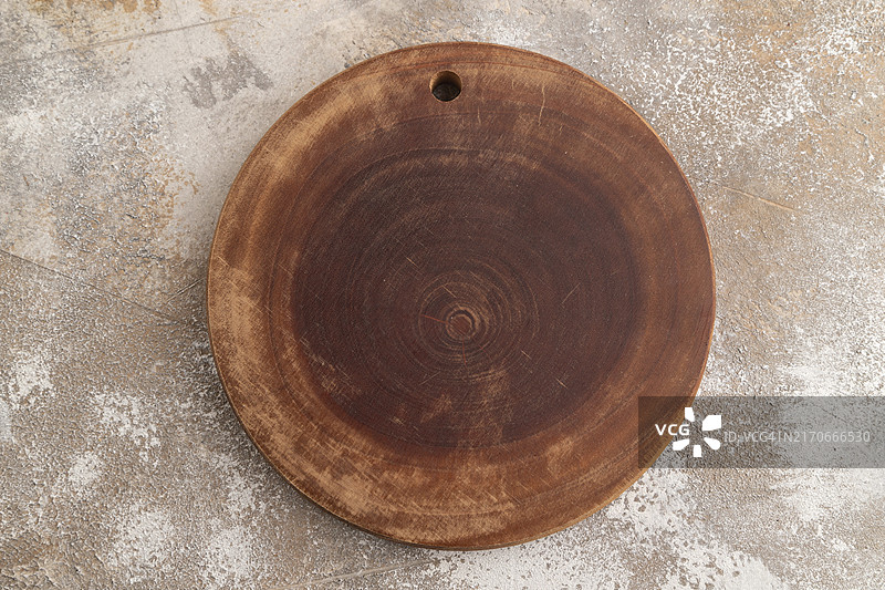 棕色水泥背景上的空圆形木制砧板，顶视图，特写，平铺图片素材