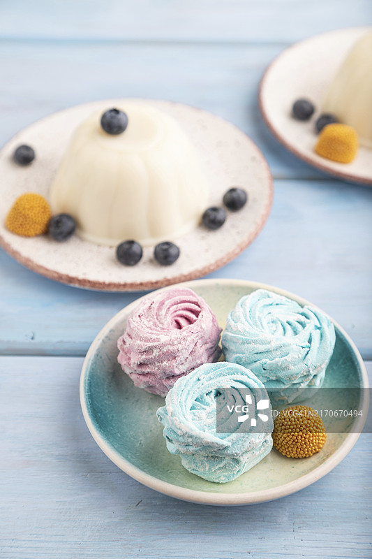 蓝色木质背景上的棉花糖牛奶冻，侧视特写图片素材