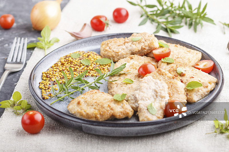 灰色陶瓷盘中配番茄香草的炸猪排图片素材