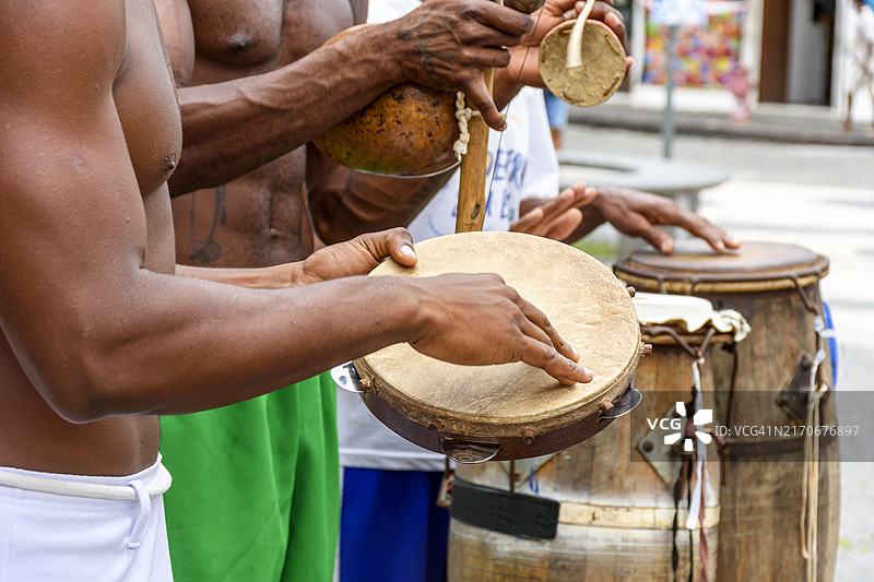 在巴西巴伊亚萨尔瓦多街头，音乐家演奏用于卡波耶拉和其他巴西文化活动的非洲传统乐器图片素材