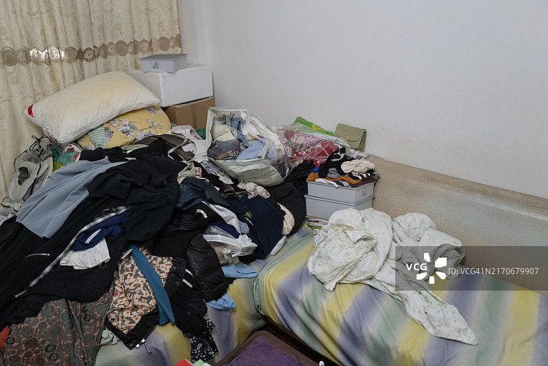 堆满衣物的凌乱客厅沙发图片素材