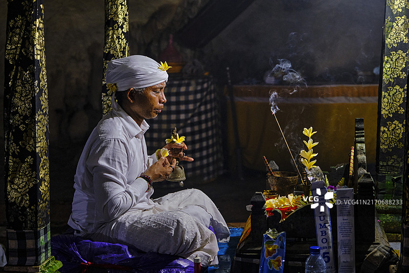 印度尼西亚巴厘岛珀尼达岛，信徒在Goa Giri Putri寺庙洞穴中祈祷图片素材
