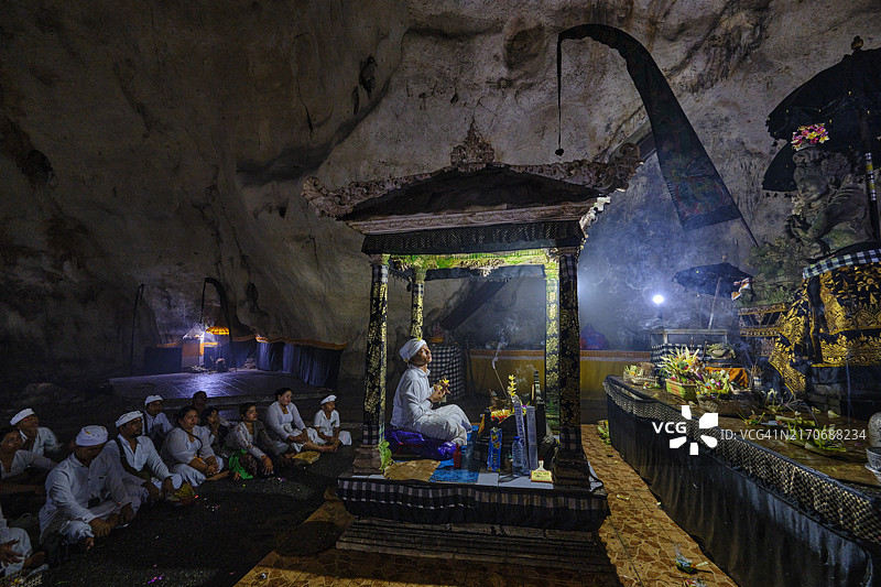 印度尼西亚巴厘岛珀尼达岛，信徒在Goa Giri Putri寺庙洞穴中祈祷图片素材