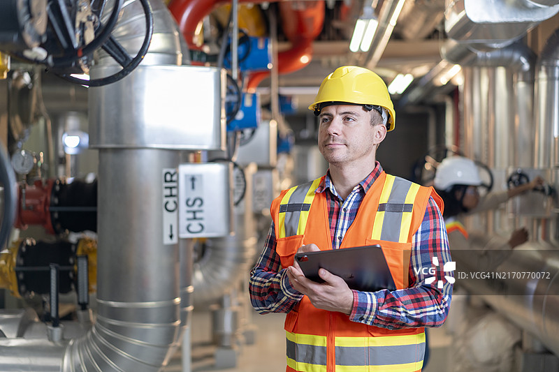 专业石化工人检查发电厂或炼油厂中的燃气发电机图片素材