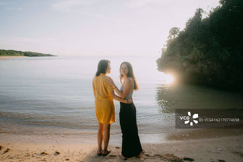 母亲和青少年女儿在海滩上图片素材