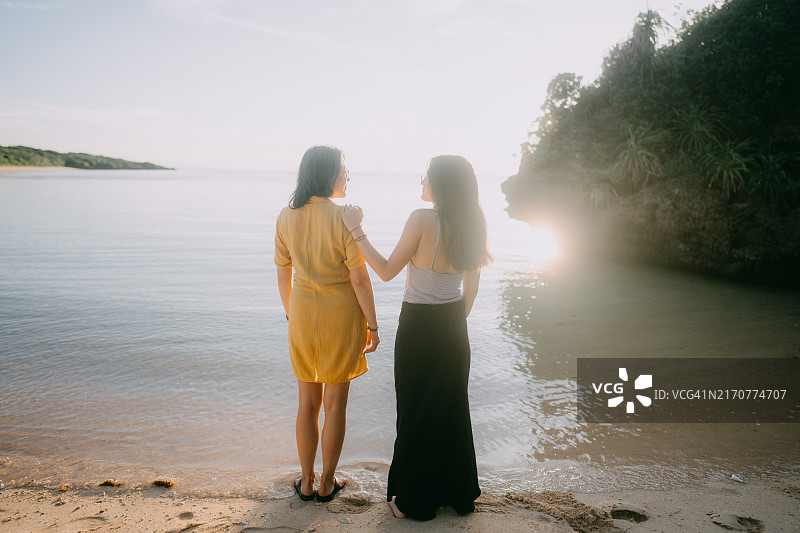 母亲和青少年女儿在海滩上图片素材