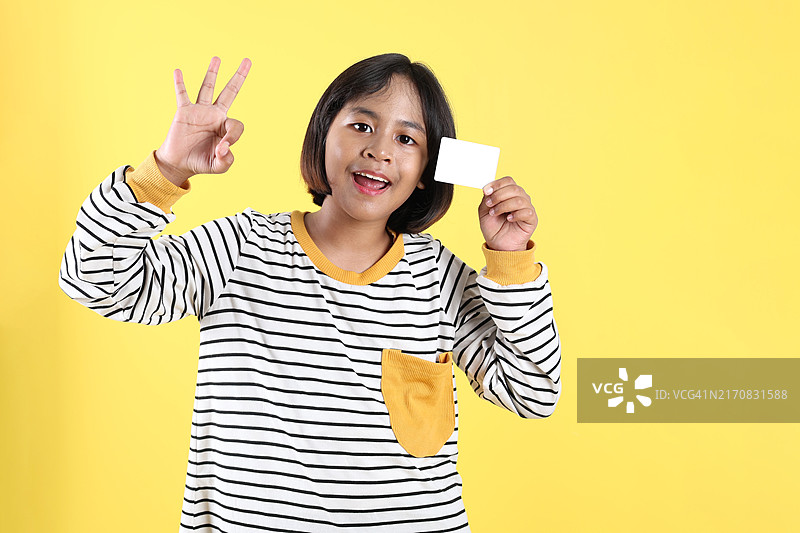 亚洲孩子们手持白色空银行卡并做出OK手势图片素材