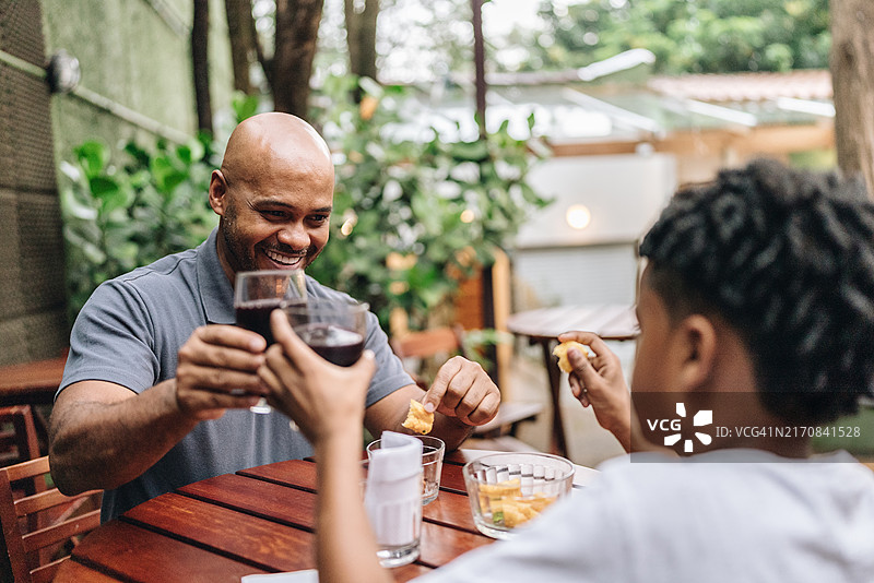父子在餐厅祝酒图片素材
