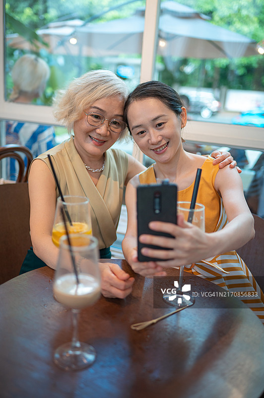 母亲和女儿在咖啡馆一起自拍图片素材