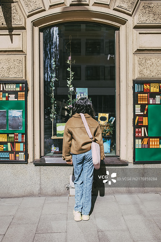 女孩站在书店窗户旁的背影图片素材