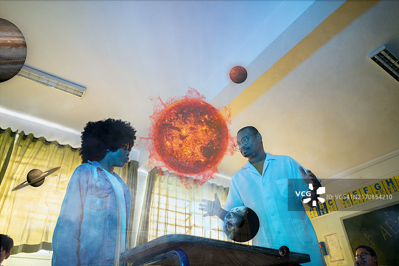 在科学课上与老师一起使用太阳系全息图学习的学生图片素材