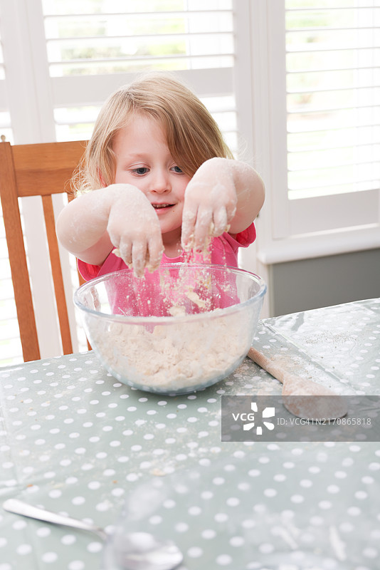 3岁女孩在厨房桌子上准备水果酥皮图片素材