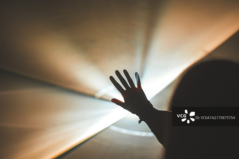 光线抽象背景上的张开的手图片素材