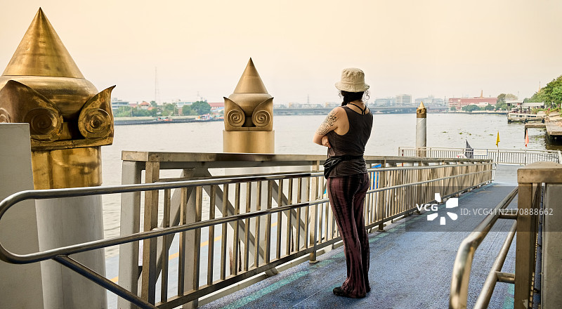 站在渡轮码头看河的游客图片素材