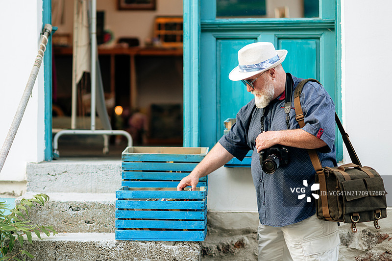 夏季旅行中挑选纪念品的中年游客，手持相机图片素材