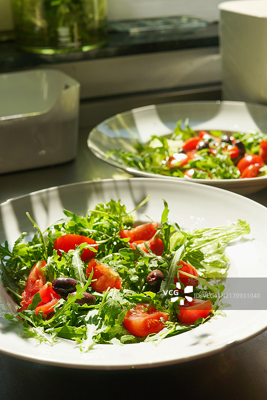 新鲜绿色沙拉配芝麻菜、番茄、橄榄和蔬菜图片素材