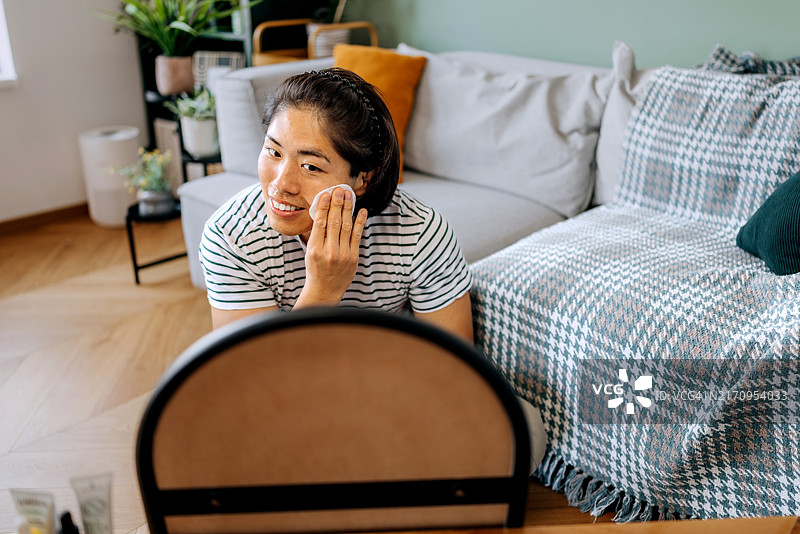 年轻帅气的男士在家用棉垫清洁面部图片素材