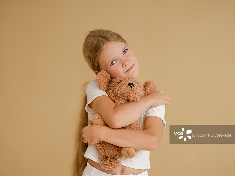 一个女孩抱着手中的毛绒玩具的肖像图片素材
