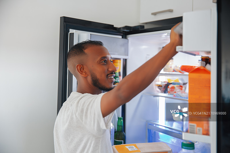 男人在家中伸手进冰箱图片素材