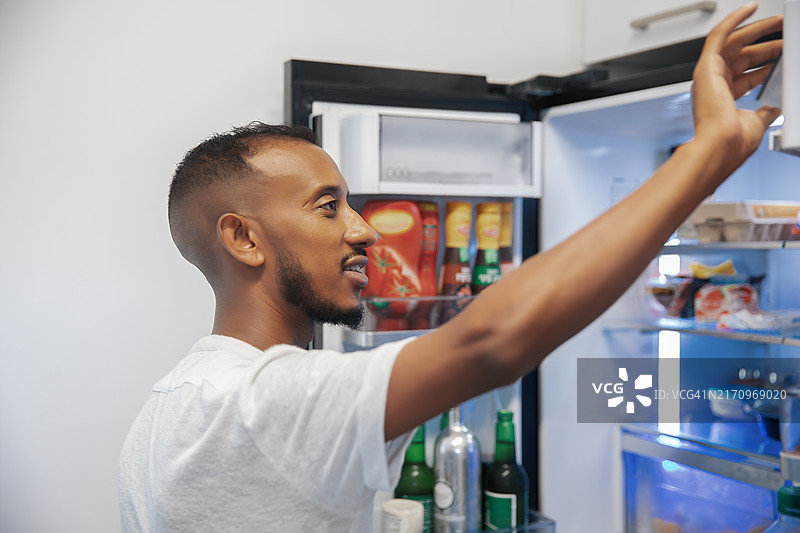 男人在家中伸手进冰箱图片素材