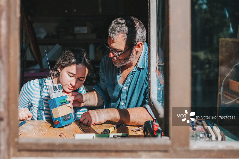 父女在工作室一起升级改造电子垃圾图片素材