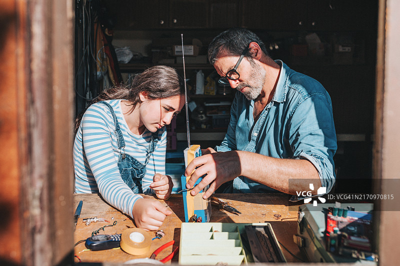 父女在工作室一起升级改造电子垃圾图片素材