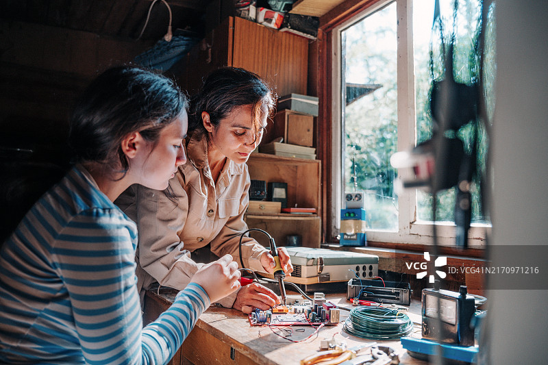 女人和女儿在工作室升级改造电子垃圾图片素材