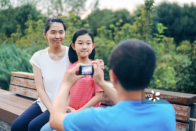 父亲为母亲和女儿拍照图片素材