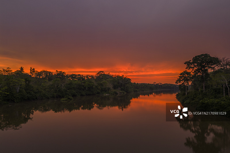 日落时森林环绕的河流图片素材
