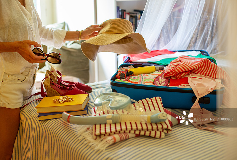 女人收拾行李箱准备去海滩度假图片素材