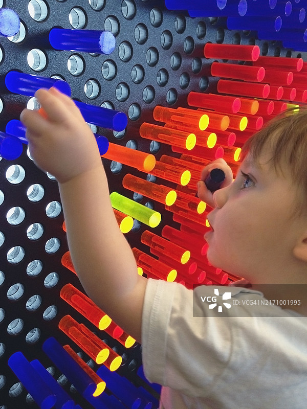 玩彩色木钉的男孩图片素材