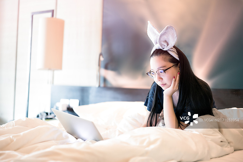 年轻亚洲女孩在床上图片素材